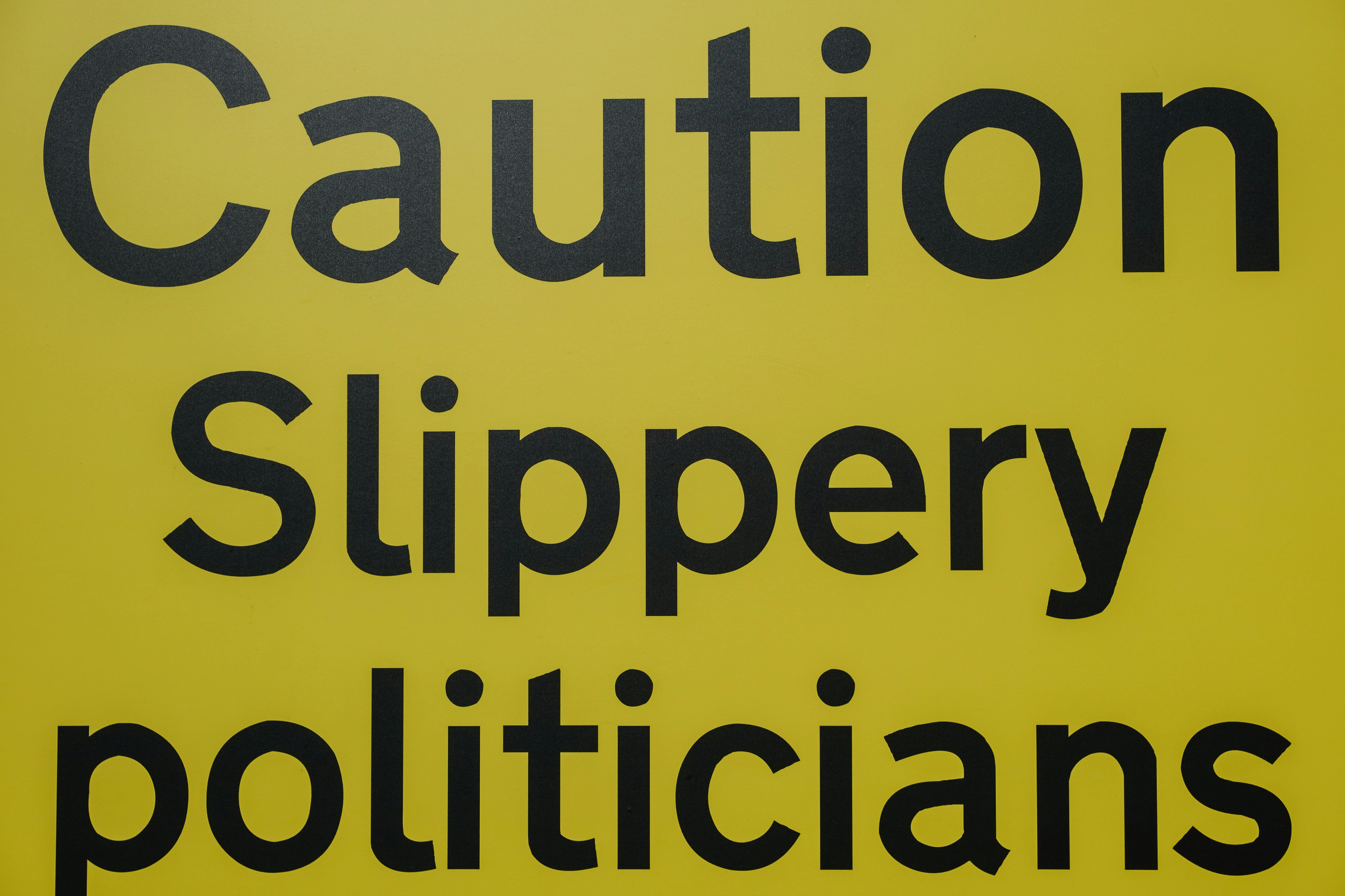 sign saying "Caution slippery politicians"